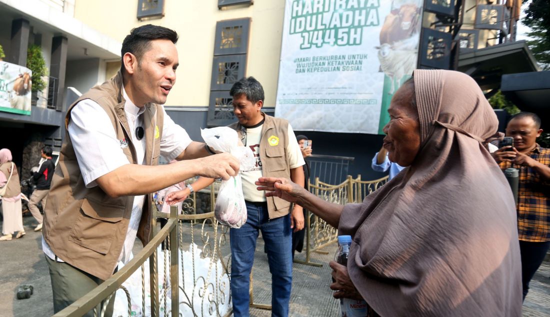 Ben Kasyafani dan Wasekum DPP LDII Ruly Siswa Bernaputra menyerahkan daging hewan kurban kepada masyarakat di DPP LDII, Jakarta, Senin (17/6). - JPNN.com