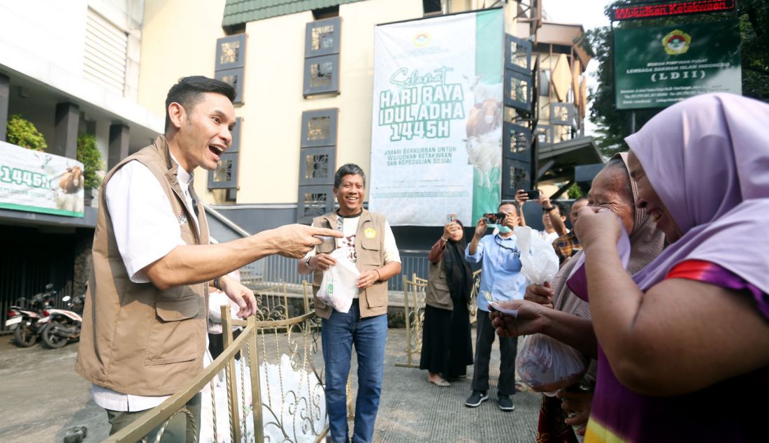 Ben Kasyafani dan Wasekum DPP LDII Ruly Siswa Bernaputra menyerahkan daging hewan kurban kepada masyarakat di DPP LDII, Jakarta, Senin (17/6). - JPNN.com