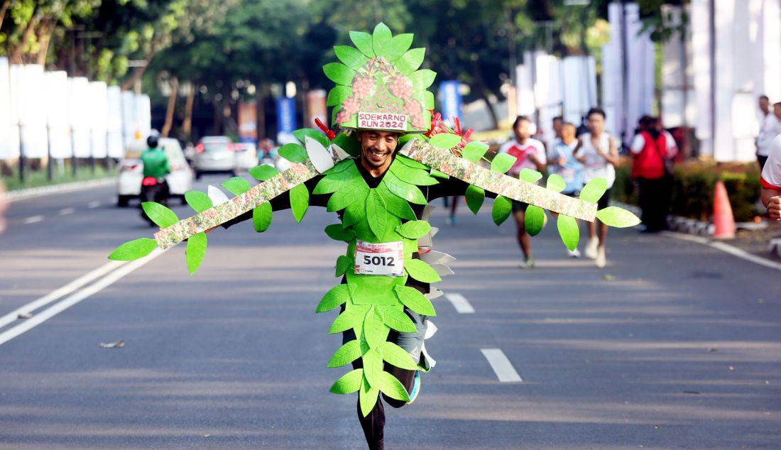 Pelari menggunakan costum daun pohon kopi mengikuti Soekarno Run dalam rangka puncak peringatan Bulan Bung Karno di Parkir Timur GBK, Jakarta, Minggu (30/6). - JPNN.com