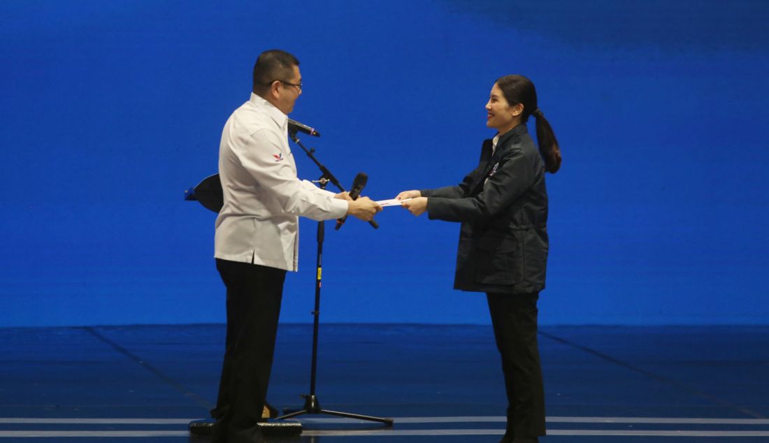 Ketua umum Partai Perindo Hary Tanoesoedibjo saat menyerahkan SK ketua umum Partai Perindo kepada Ketua Harian Nasional DPP Partai Perindo Angela Tanoesoedibjo disela acara penutupan musyawarah kerja nasional (Mukernas) Partai Perindo, Jakarta, Rabu (31/7). Penutupan Mukernas ini mengangkat Ketua Harian Nasional DPP Partai Perindo Angela Tanoesoedibjo menjadi Ketua umum Partai Perindo menggantikan Hary Tanoesoedibjo yang kini menjabat Ketua Majelis Persatuan Partai Perindo. - JPNN.com