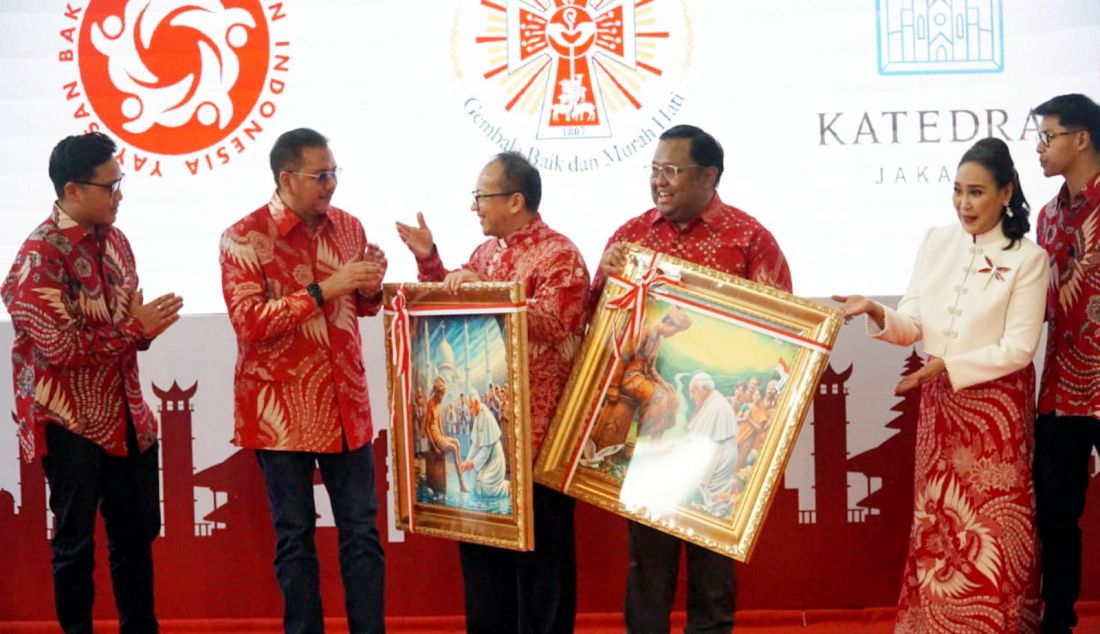 Ketua Esoterika Forum Spiritualitas Denny JA menyerahkan karya lukisannya berjudul 'Paus Mencuci Kaki Rakyat Indonesia' kepada Pastor Kepala Gereja Katedral Jakarta Romo Albertus Hani Rudi Hartoko disaksikan Penggagas dan Ketua Umum YBKI Mulia Jayaputri saat acara Bakti Indonesia di Gereja Katedral Jakarta, Selasa (6/8). Denny JA menyerahkan dua lukisan kepada Gereja Katedral yang berjudul 'Paus Mencuci Kaki Rakyat Indonesia' jelang kedatangan Paus Fransiskus ke Indonesia. - JPNN.com