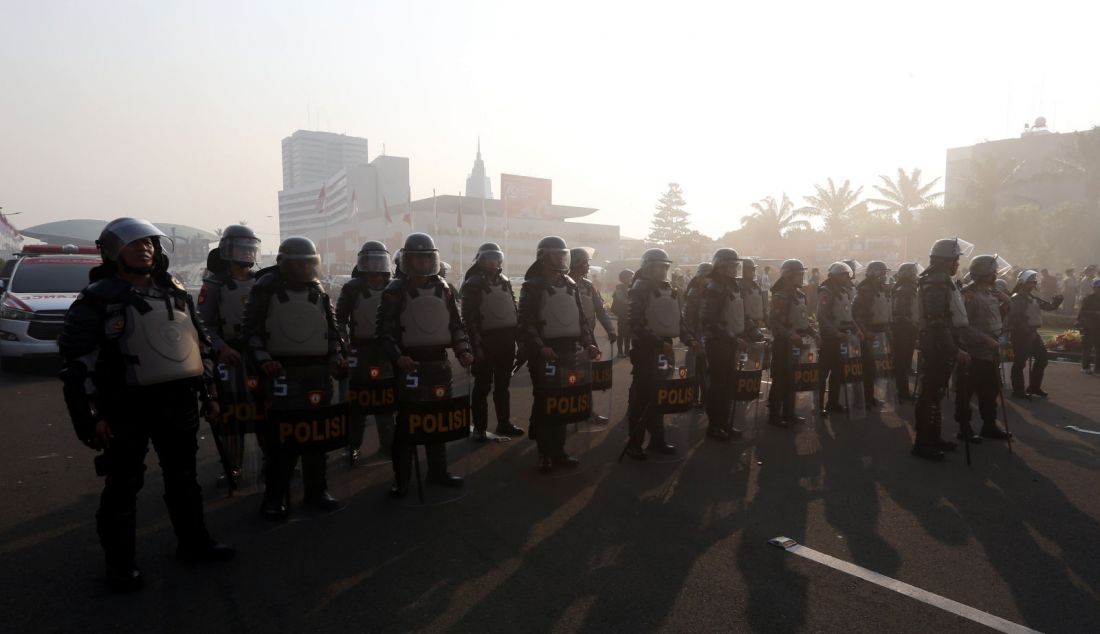 Petugas kepolisan saat mengamankan aksi unjuk rasa di depan Gedung DPR, Jakarta, Kamis (22/8). Aksi tersebut sebagai penolakan terhadap revisi Undang-Undang Pemilihan Kepala Daerah (UU Pilkada). - JPNN.com