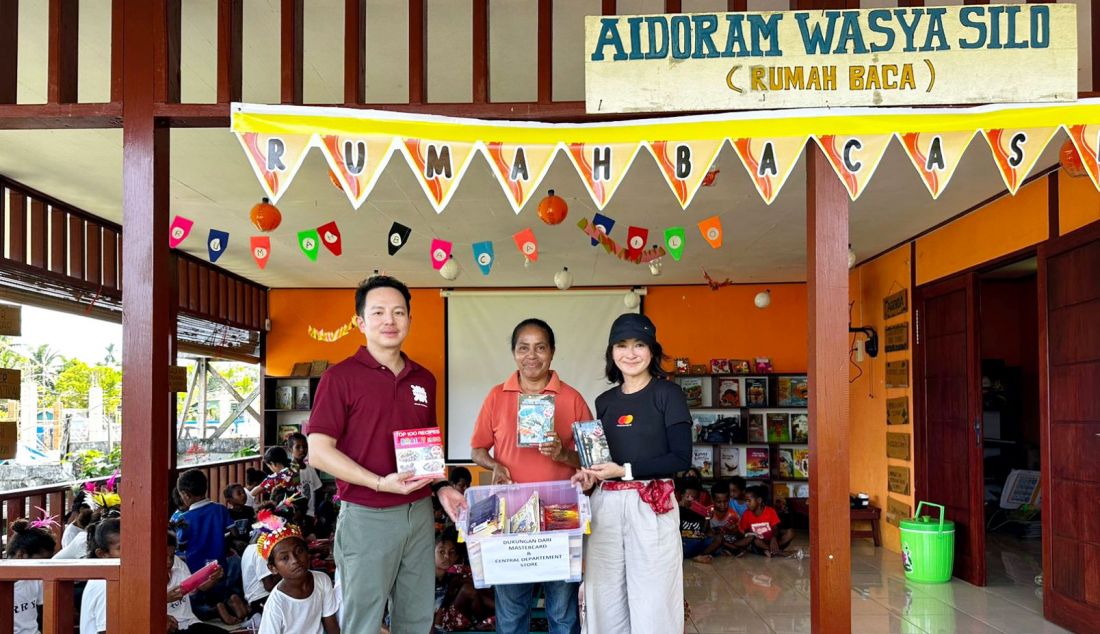 Kong Surapongpracha, Managing Director Central Department Store (Central) (pertama dari kiri) dan Aileen Goh, Country Manager, Indonesia, Mastercard (pertama dari kanan), menunjukkan dukungan untuk literasi dan edukasi masyarakat dengan mendonasikan buku selama kunjungan ke Rumah Baca Silo dan Rumah Baca Maranatha di Biak. - JPNN.com