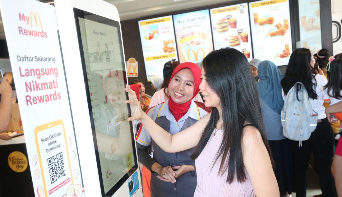 Salah satu kru McDonald’s Jombang mendampingi pelanggan untuk melakukan pemesanan melalui teknologi Self-Ordering Kiosk (SOK) untuk pemesanan tanpa antre. - JPNN.com