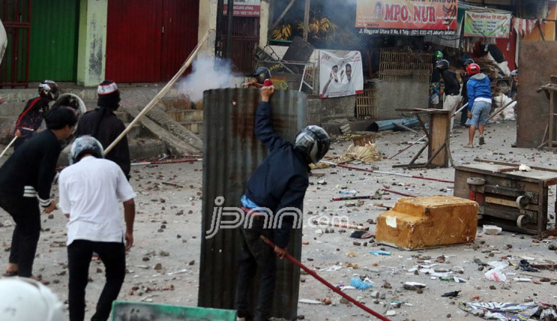 Dua kelompok warga terlibat Tawuran di sekitar Stasiun Manggarai, Jakarta, Minggu (8/1). Tawuran warga itu semakin mencekam karena Puluhan orang terlihat membawa senjata tajam, senapan angin, bongkahan batu dan petasan. imbas dari tawuran tersebut membuat warga dan penumpang kereta ketakutan dan beberapa ruas jalan ditutup. - JPNN.com