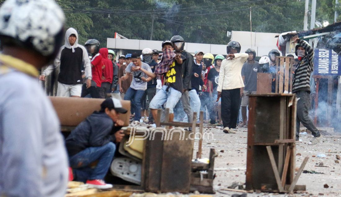 Dua kelompok warga terlibat Tawuran di sekitar Stasiun Manggarai, Jakarta, Minggu (8/1). Tawuran warga itu semakin mencekam karena Puluhan orang terlihat membawa senjata tajam, senapan angin, bongkahan batu dan petasan. imbas dari tawuran tersebut membuat warga dan penumpang kereta ketakutan dan beberapa ruas jalan ditutup. - JPNN.com