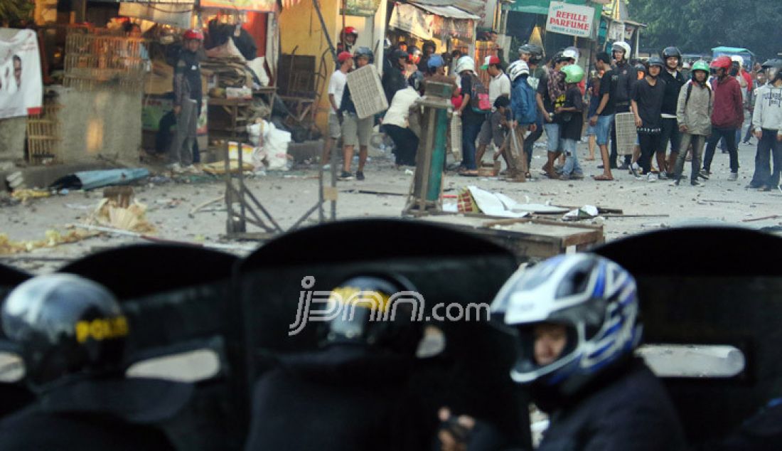 Dua kelompok warga terlibat Tawuran di sekitar Stasiun Manggarai, Jakarta, Minggu (8/1). Tawuran warga itu semakin mencekam karena Puluhan orang terlihat membawa senjata tajam, senapan angin, bongkahan batu dan petasan. imbas dari tawuran tersebut membuat warga dan penumpang kereta ketakutan dan beberapa ruas jalan ditutup. - JPNN.com