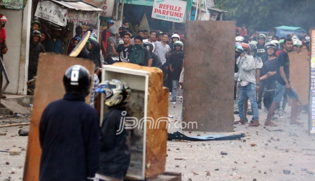 Dua kelompok warga terlibat Tawuran di sekitar Stasiun Manggarai, Jakarta, Minggu (8/1). Tawuran warga itu semakin mencekam karena Puluhan orang terlihat membawa senjata tajam, senapan angin, bongkahan batu dan petasan. imbas dari tawuran tersebut membuat warga dan penumpang kereta ketakutan dan beberapa ruas jalan ditutup. - JPNN.com