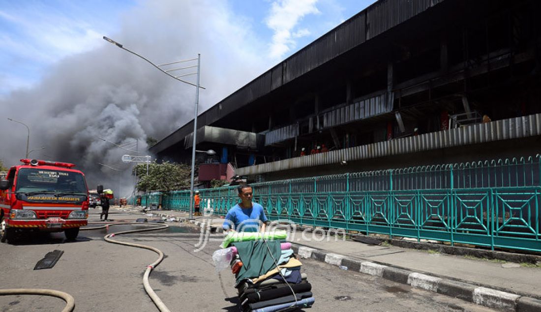 Pedagang menyelamatkan barang-barangnya dari kebakaran Pasar Senen yang terbakar di Jakarta, Kamis (19/1). Kebakaran di Pasar Senen tersebut dilaporkan terjadi sekitar pukul 04.43 WIB dan masih dalam penanganan petugas yang mengerahkan sedikitnya 50 unit mobil pemadam kebakaran. - JPNN.com