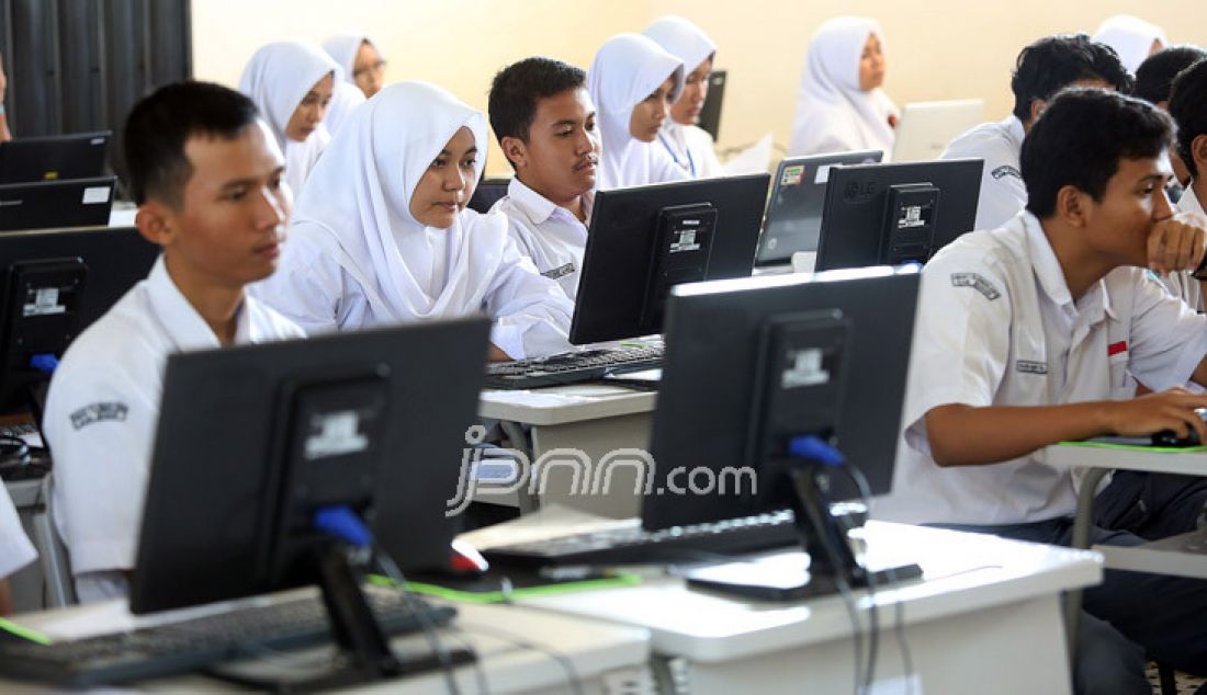 Siswa mengikuti Ujian Nasional Berbasis Komputer (UNBK) hari pertama di SMA N I Tajur Halang, Kabupaten Bogor, Jawa Barat, Senin (10/4). Pihak sekolah menyiapkan empat ruangan untuk pelaksanaan ujian tersebut dan menyiapkan jenset. - JPNN.com
