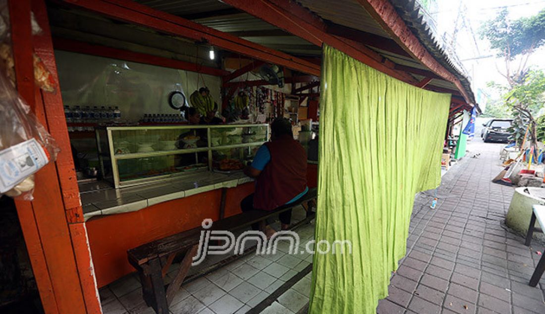 Aktivitas di rumah makan (warteg) yang tertutup tirai di kawasan Jakarta, Sabtu (26/5). Memasuki hari pertama puasa Ramadan 1438 H sejumlah operasional rumah makan tetap buka dengan menggunakan tirai penutup di siang hari. - JPNN.com