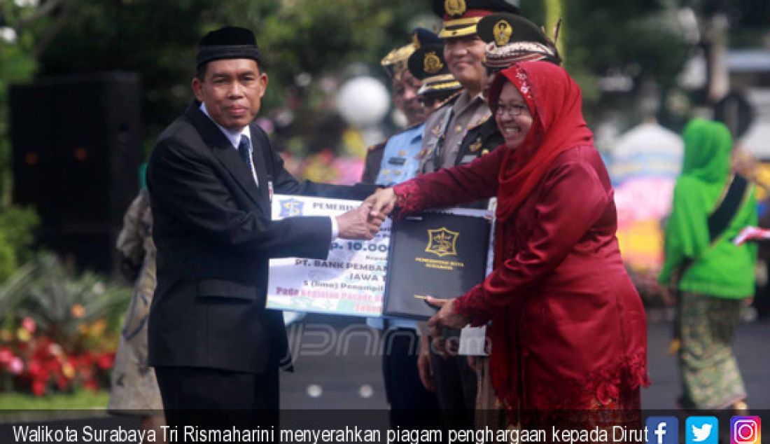 Walikota Surabaya Tri Rismaharini menyerahkan piagam penghargaan kepada Dirut Bank Jatim R Soeroso atas keikutsertaan Bank Jatim pada parade bunga - JPNN.com