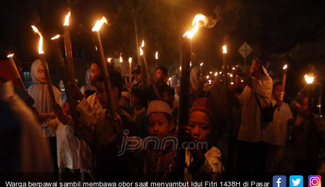 Warga berpawai sambil membawa obor saat menyambut Idul Fitri 1438H di Pasar Rebo, Jakarta, Sabtu (24/6). - JPNN.com