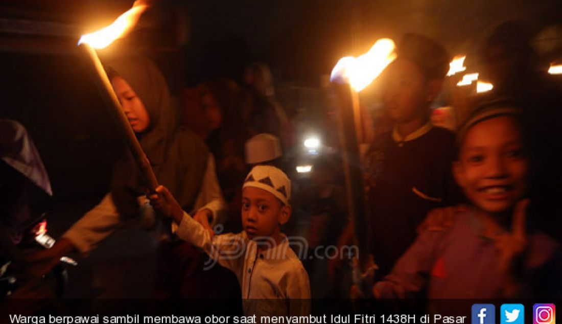 Warga berpawai sambil membawa obor saat menyambut Idul Fitri 1438H di Pasar Rebo, Jakarta, Sabtu (24/6). - JPNN.com