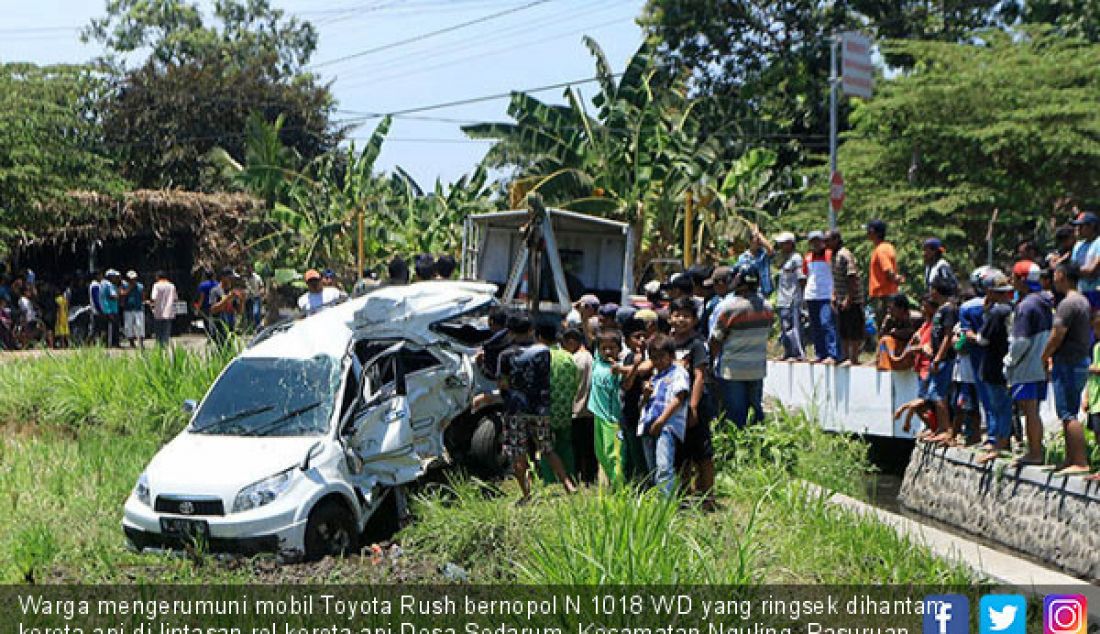 Warga mengerumuni mobil Toyota Rush bernopol N 1018 WD yang ringsek dihantam kereta api di lintasan rel kereta api Desa Sedarum, Kecamatan Nguling, Pasuruan, Kamis (21/9). 1 dari 4 penumpang mobil meninggal dunia. - JPNN.com