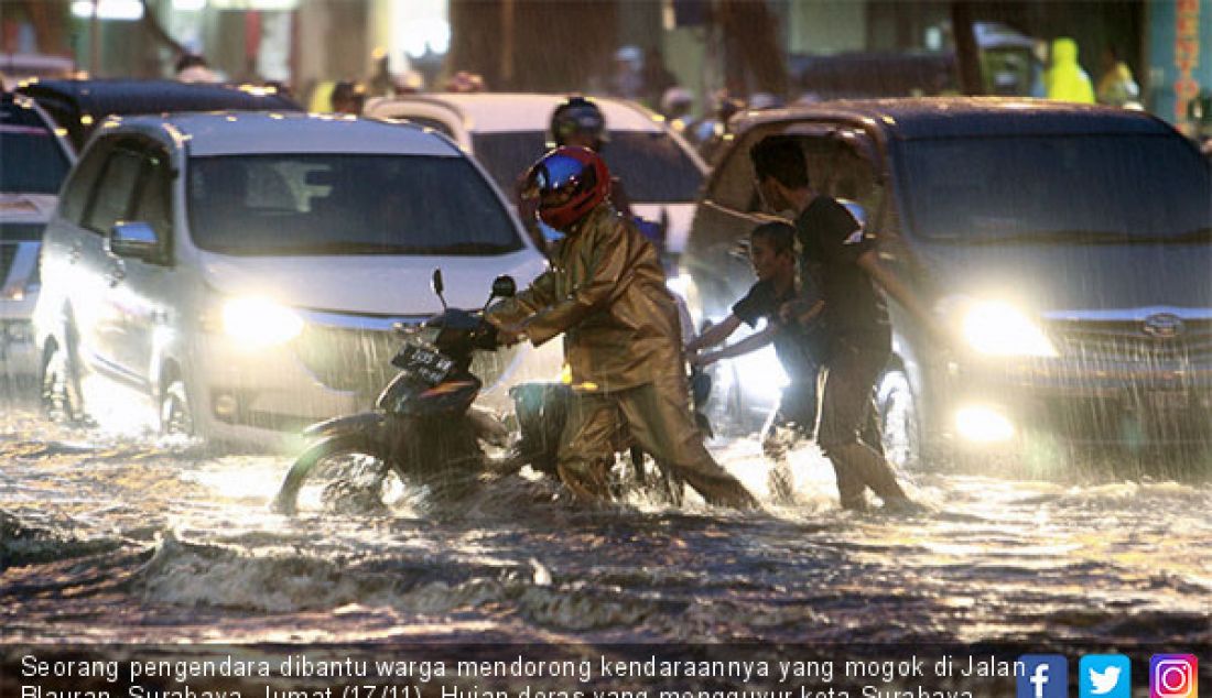 Seorang pengendara dibantu warga mendorong kendaraannya yang mogok di Jalan Blauran, Surabaya, Jumat (17/11). Hujan deras yang mengguyur kota Surabaya selama beberapa jam, membuat beberapa wilayah tergenang air. - JPNN.com