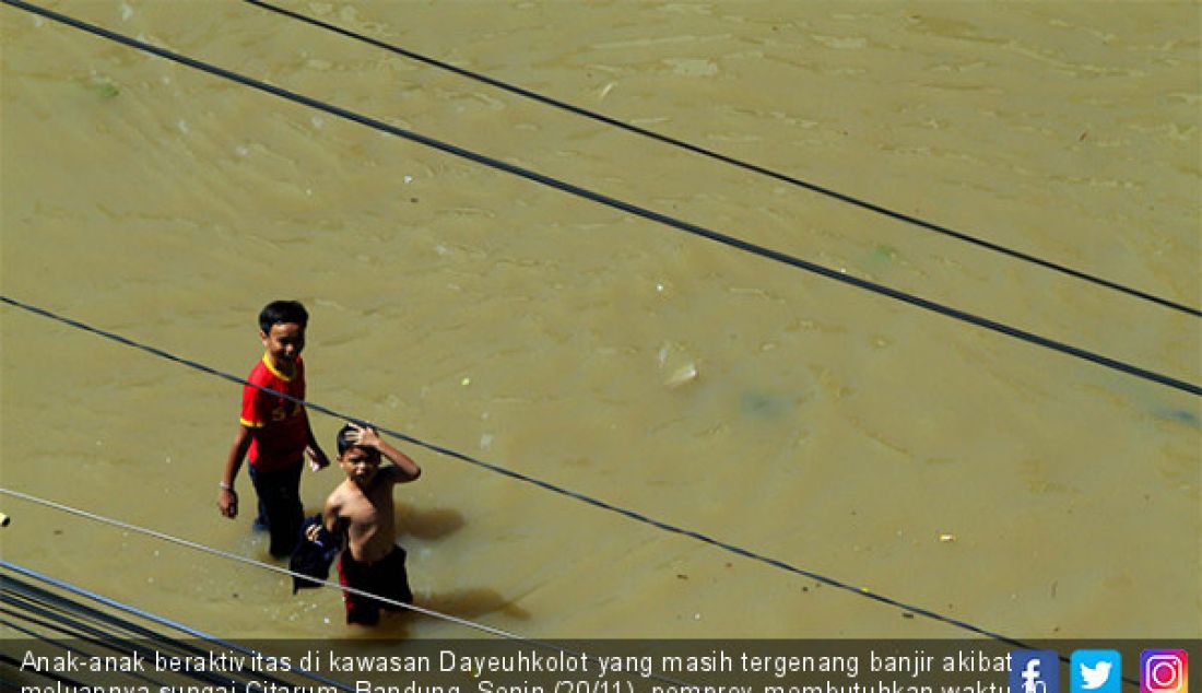 Anak-anak beraktivitas di kawasan Dayeuhkolot yang masih tergenang banjir akibat meluapnya sungai Citarum, Bandung, Senin (20/11). pemprov membutuhkan waktu 10 Tahun untuk menjadikan Sungai Citarum bebas banjir. - JPNN.com