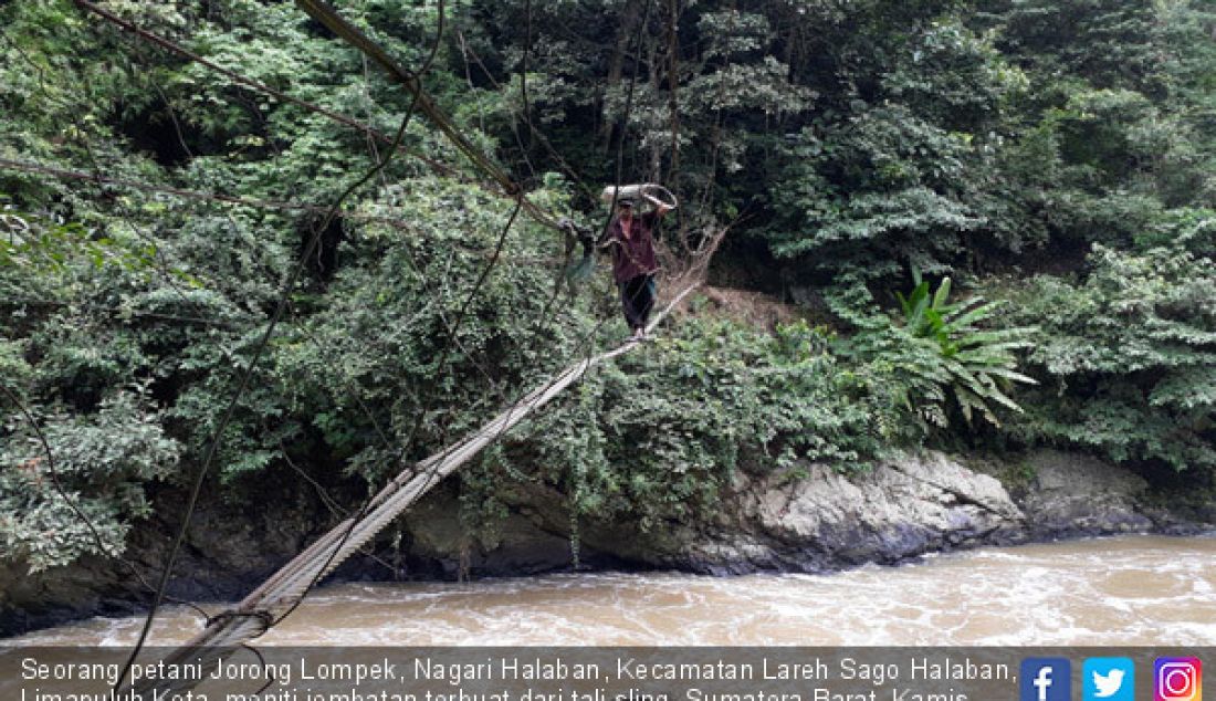 Seorang petani Jorong Lompek, Nagari Halaban, Kecamatan Lareh Sago Halaban, Limapuluh Kota, meniti jembatan terbuat dari tali sling, Sumatera Barat, Kamis (22/2). - JPNN.com