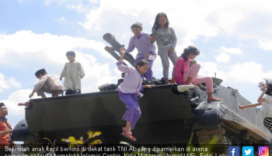 Sejumlah anak kecil berfoto di dekat tank TNI AL yang dipamerkan di arena pameran alutsista kompleks Islamic Center, Kota Mataram, Jumat (4/5). - JPNN.com