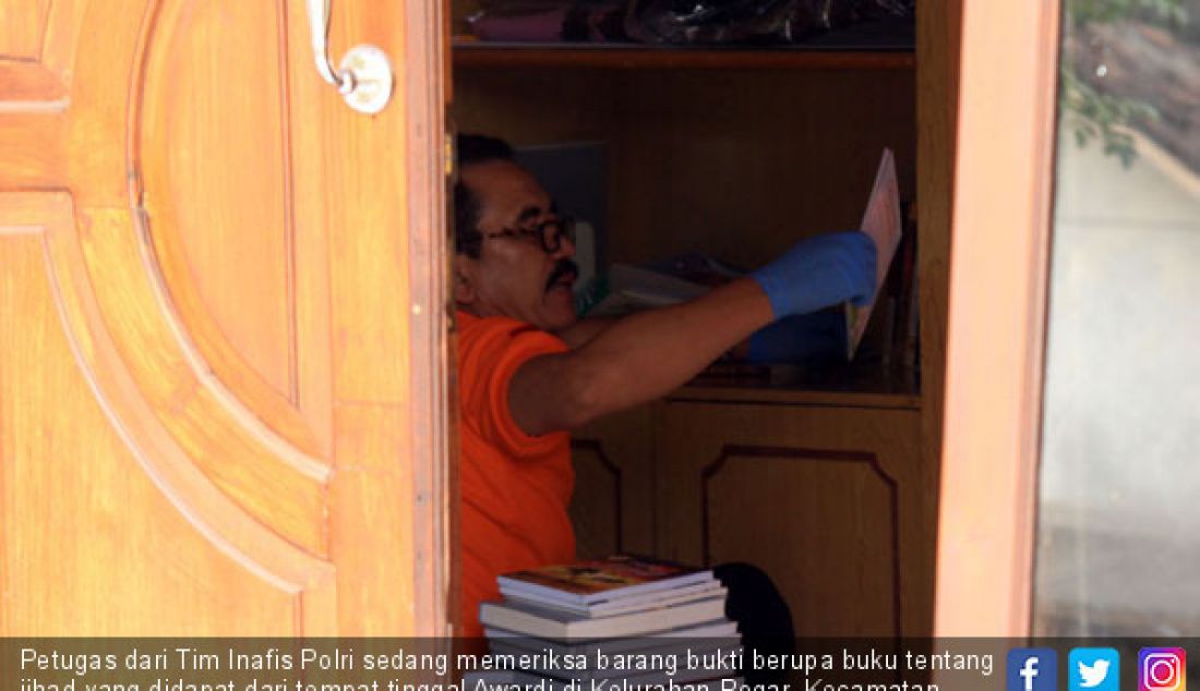 Petugas dari Tim Inafis Polri sedang memeriksa barang bukti berupa buku tentang jihad yang didapat dari tempat tinggal Awardi di Kelurahan Pogar, Kecamatan Bangil, Kabupaten Pasuruan, Kamis (5/7) siang. - JPNN.com