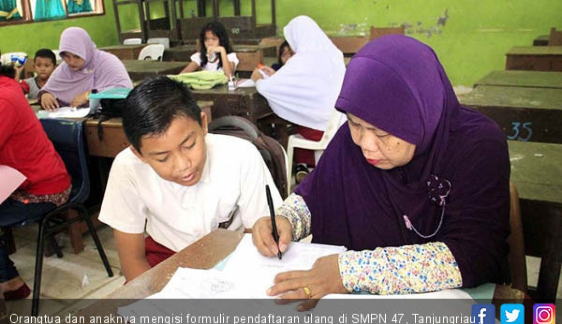 Orangtua dan anaknya mengisi formulir pendaftaran ulang di SMPN 47, Tanjungriau, Sekupang, Senin (9/7). - JPNN.com