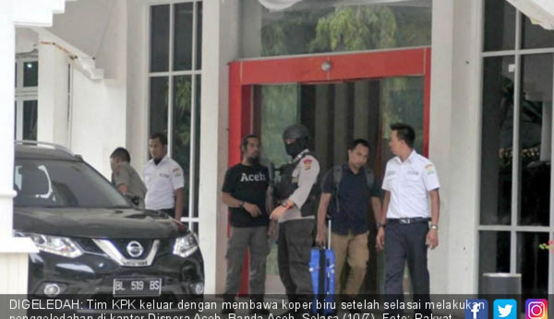 DIGELEDAH: Tim KPK keluar dengan membawa koper biru setelah selasai melakukan penggeledahan di kantor Dispora Aceh, Banda Aceh, Selasa (10/7). - JPNN.com