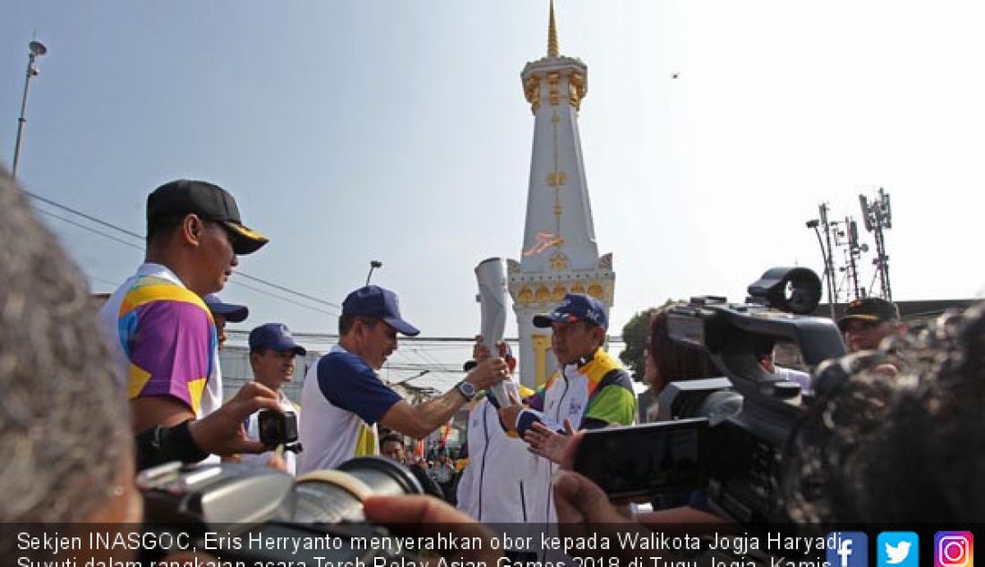 Sekjen INASGOC, Eris Herryanto menyerahkan obor kepada Walikota Jogja Haryadi Suyuti dalam rangkaian acara Torch Relay Asian Games 2018 di Tugu Jogja, Kamis (19/7). Dari Jogja, obor Asian Games 2018 dibawa menuju 52 kota. - JPNN.com