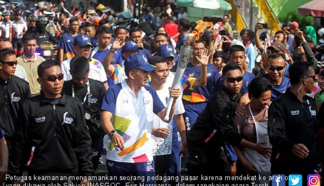 Petugas keamanan mengamankan seorang pedagang pasar karena mendekat ke arah obor yang dibawa oleh Sekjen INASGOC, Eris Herryanto, dalam rangkaian acara Torch Relay Asian Games 2018 di Tugu Jogja, Kamis (19/7). - JPNN.com