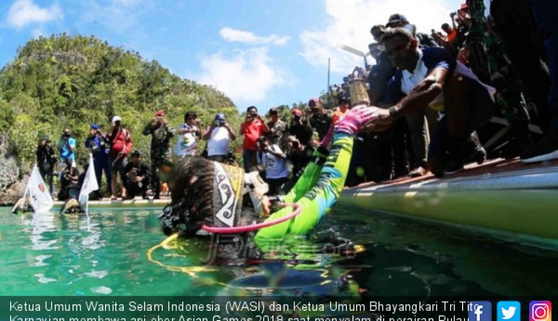 Ketua Umum Wanita Selam Indonesia (WASI) dan Ketua Umum Bhayangkari Tri Tito Karnavian membawa api obor Asian Games 2018 saat menyelam di perairan Pulau Piaynemo, Raja Ampat, Papua Barat. - JPNN.com