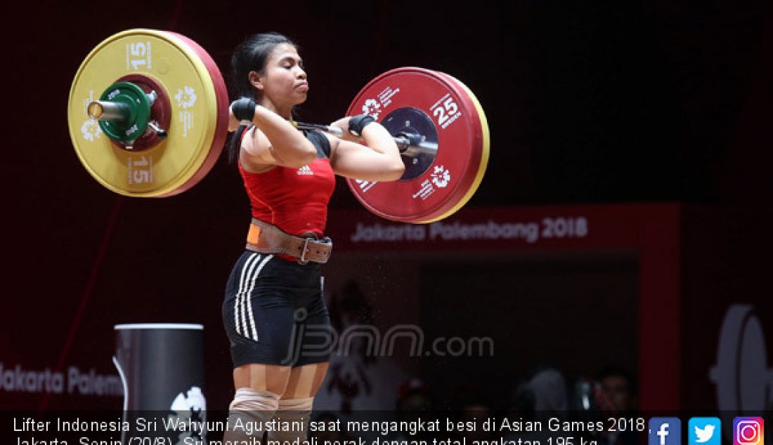 Lifter Indonesia Sri Wahyuni Agustiani saat mengangkat besi di Asian Games 2018, Jakarta, Senin (20/8). Sri meraih medali perak dengan total angkatan 195 kg. - JPNN.com