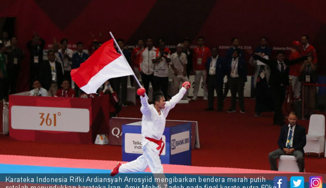 Karateka Indonesia Rifki Ardiansyah Arrosyiid mengibarkan bendera merah putih setelah menundukkan karateka Iran, Amir Mahdi Zadeh pada final karate putra 60kg pada Asian Games 2018, Senayan, Jakarta, Sabtu (25/8). - JPNN.com