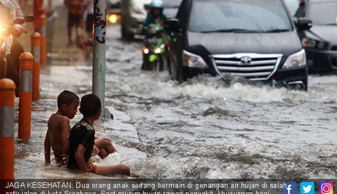 JAGA KESEHATAN: Dua orang anak sedang bermain di genangan air hujan di salah satu jalan di kota Surabaya. Saat musim hujan rawan penyakit, khususnya bagi anak-anak yang daya tahan tubuhnya belum sempurna. - JPNN.com