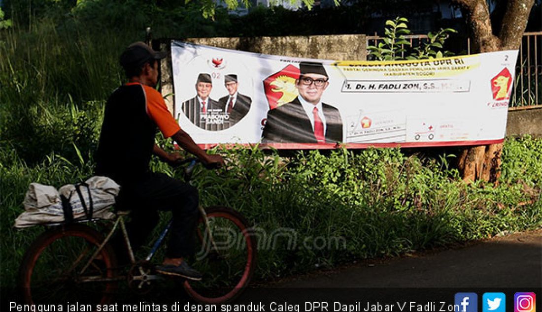 Pengguna jalan saat melintas di depan spanduk Caleg DPR Dapil Jabar V Fadli Zon, Kabupaten Bogor, Selasa (12/2). - JPNN.com