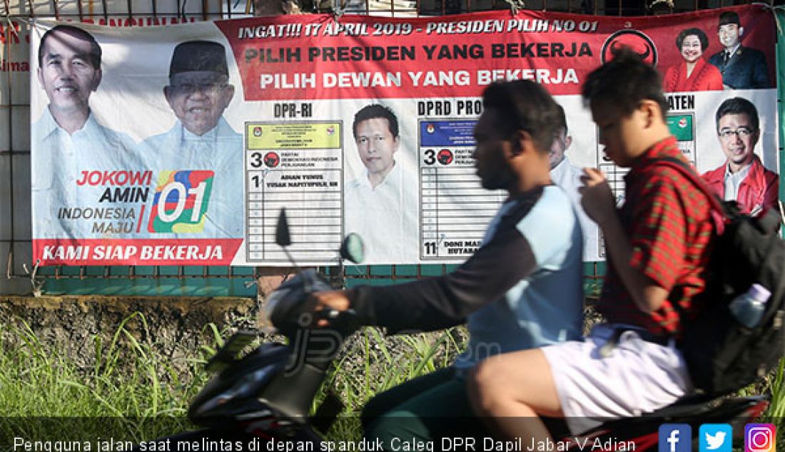 Pengguna jalan saat melintas di depan spanduk Caleg DPR Dapil Jabar V Adian Yunus Yusak Napitupulu, Kabupaten Bogor, Selasa (12/2). - JPNN.com