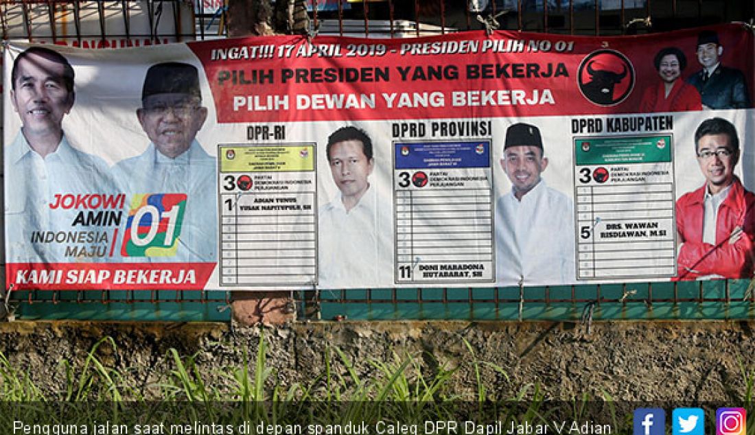 Pengguna jalan saat melintas di depan spanduk Caleg DPR Dapil Jabar V Adian Yunus Yusak Napitupulu, Kabupaten Bogor, Selasa (12/2). - JPNN.com