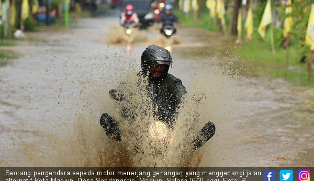 Seorang pengendara sepeda motor menerjang genangan yang menggenangi jalan alternatif Kota Madiun, Desa Sendangrejo, Madiun, Selasa (5/3) pagi. - JPNN.com