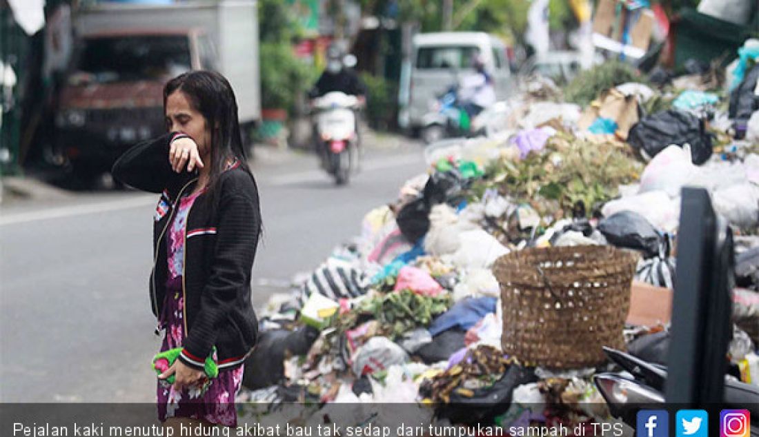 Pejalan kaki menutup hidung akibat bau tak sedap dari tumpukan sampah di TPS Lempuyangan, Kota Jogja, Rabu (27/3). - JPNN.com