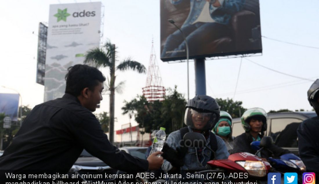 Warga membagikan air minum kemasan ADES, Jakarta, Senin (27/5). ADES menghadirkan billboard #NiatMurni Ades pertama di Indonesia yang terbuat dari sampah plastik botol. - JPNN.com