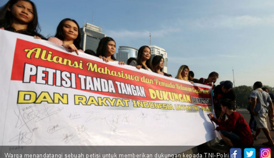 Warga menandatangi sebuah petisi untuk memberikan dukungan kepada TNI-Polri di Kawasan Patung Kuda, Jakarta, Minggu (16/6). - JPNN.com