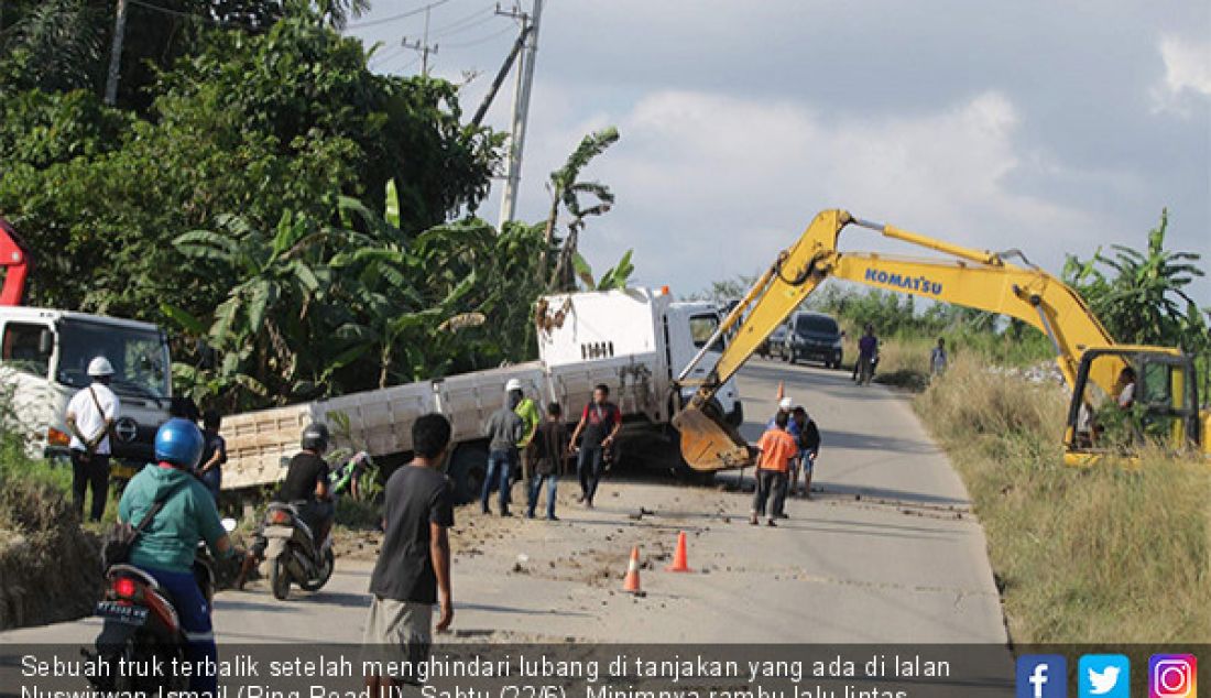 Sebuah truk terbalik setelah menghindari lubang di tanjakan yang ada di lalan Nuswirwan Ismail (Ring Road II), Sabtu (22/6). Minimnya rambu lalu lintas membuat pengendara yang kurang menguasi medan dan kerap memicu kecelakaan. - JPNN.com