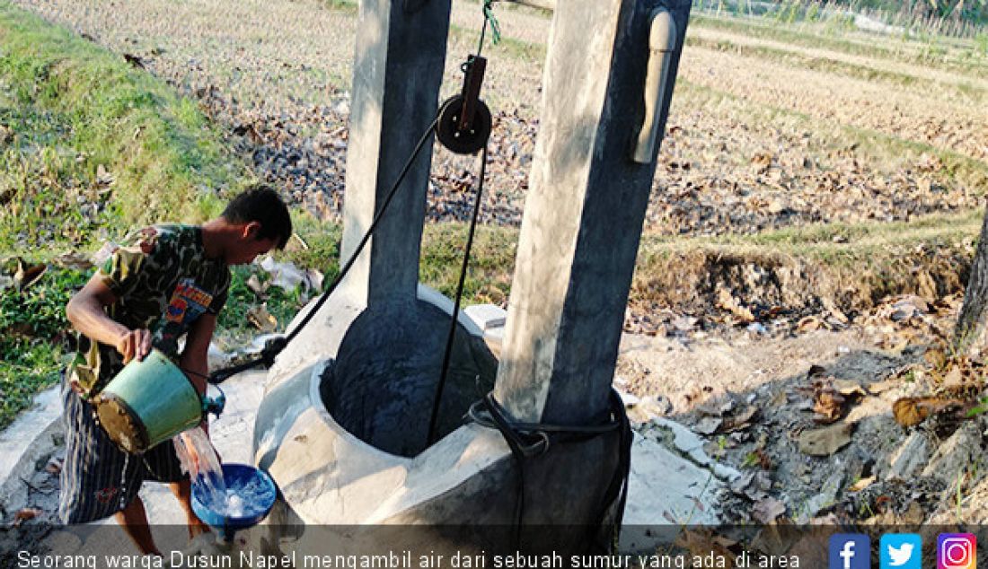 Seorang warga Dusun Napel mengambil air dari sebuah sumur yang ada di area persawahan, Kamis (18/7). - JPNN.com