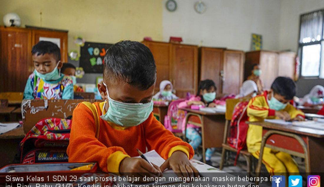 Siswa Kelas 1 SDN 29 saat proses belajar dengan mengenakan masker beberapa hari ini, Riau, Rabu (31/7). Kondisi ini akibat asap kiriman dari kebakaran hutan dan lahan (Karhutla) yang membuat kualitas udara di Pekanbaru membu - JPNN.com