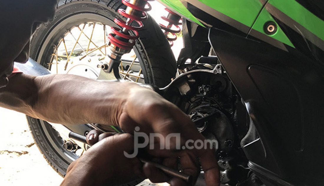 Mekanik melakukan perbaikan sekaligus perawatan sepeda motor pelanggan di bengkel miliknya, kota Ciledug, Tangerang, Selasa (10/9). - JPNN.com