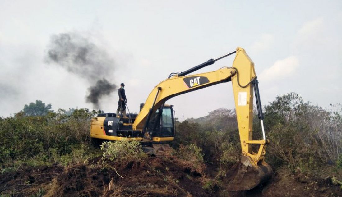 Alat berat jenis exavator menggali siring untuk merelokasi kebun plasma kelapa sawit di lahan gambut yang terbakar di Desa Ujung Padang, Kecamatan Kota Mukomuko,Kabupaten Mukomuko, Bengkulu. - JPNN.com