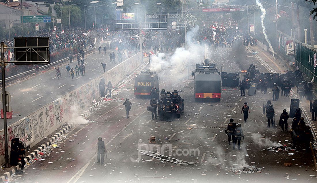 Petugas keamanan saat bentrok dengan pendemo di depan Gedung DPR, Jakarta, Selasa (24/9). - JPNN.com