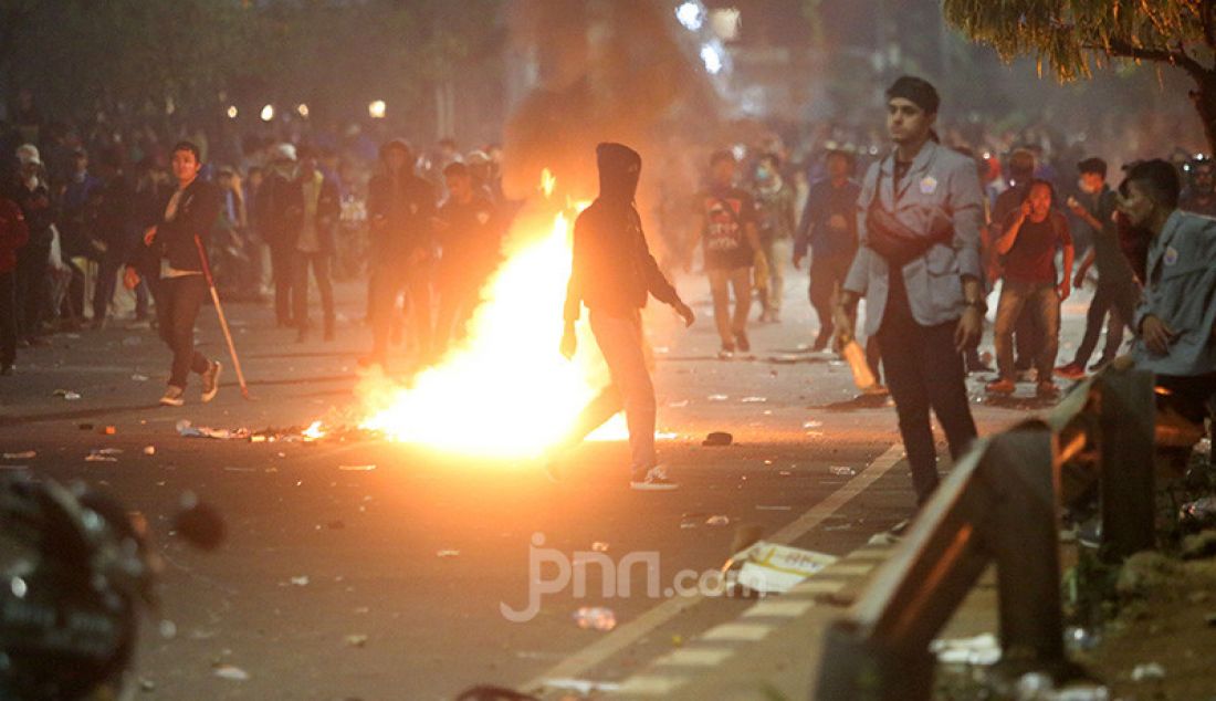 Petugas keamanan saat bentrok dengan pendemo di depan Gedung DPR, Jakarta, Selasa (24/9). - JPNN.com