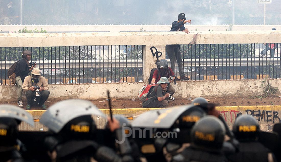 Petugas keamanan saat bentrok dengan pendemo di depan Gedung DPR, Jakarta, Selasa (24/9). - JPNN.com