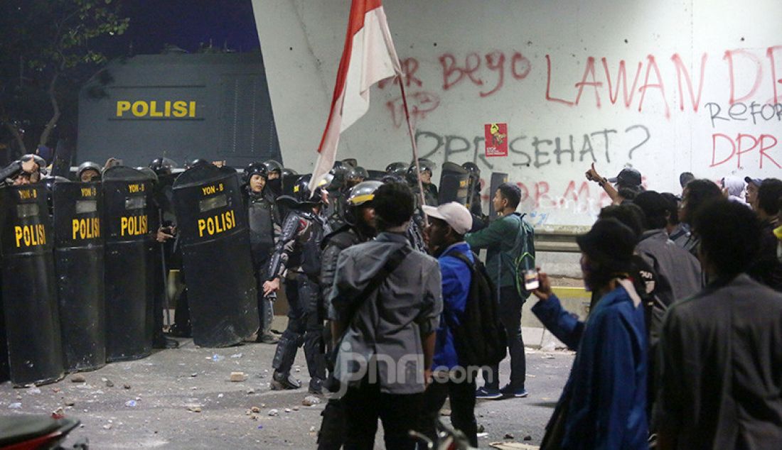 Petugas keamanan saat bentrok dengan pendemo di depan Gedung DPR, Jakarta, Selasa (24/9). - JPNN.com