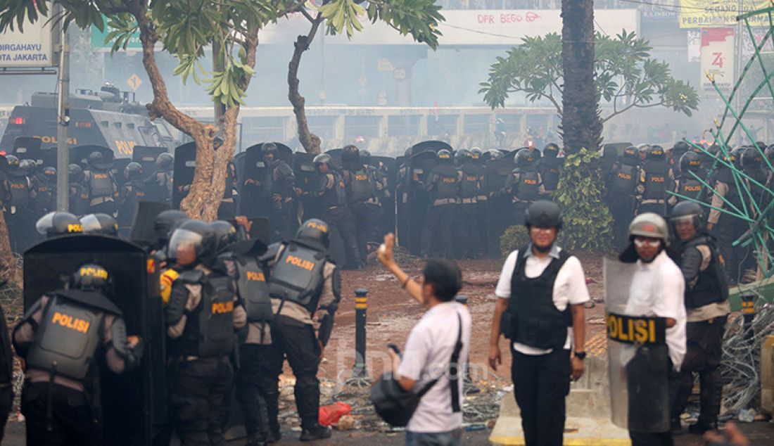 Petugas keamanan saat bentrok dengan pendemo di depan Gedung DPR, Jakarta, Selasa (24/9). - JPNN.com