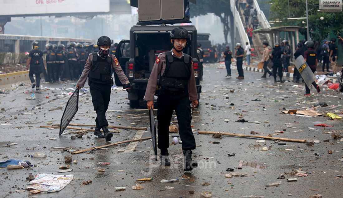 Petugas keamanan saat bentrok dengan pendemo di depan Gedung DPR, Jakarta, Selasa (24/9). - JPNN.com